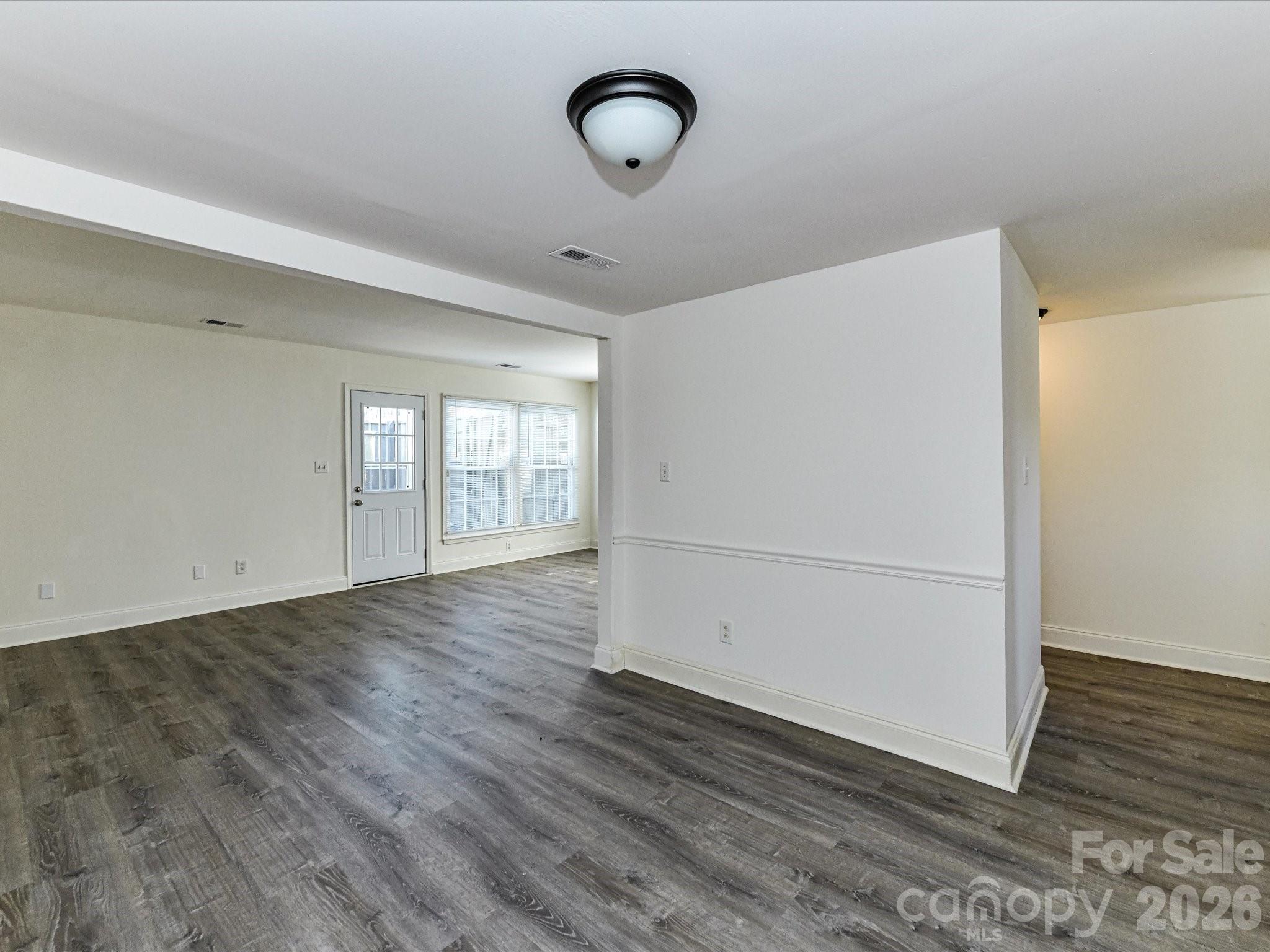 8322 Knights Bridge Road Charlotte, NC 28210 - Photo 13 of 37 a view of an empty room with wooden floor and a window