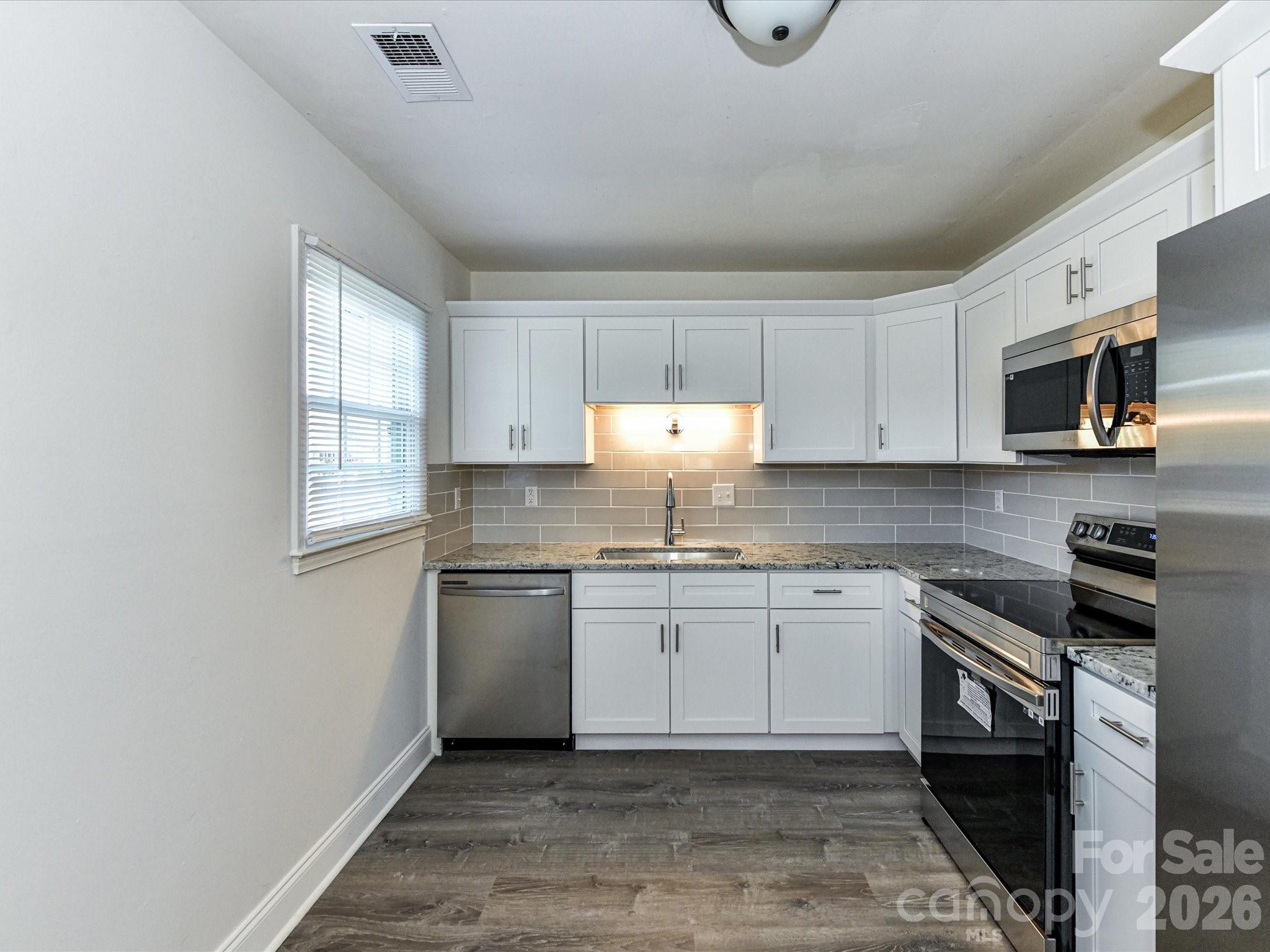 8322 Knights Bridge Road Charlotte, NC 28210 - Photo 17 of 37 a kitchen with stainless steel appliances granite countertop a sink stove and microwave