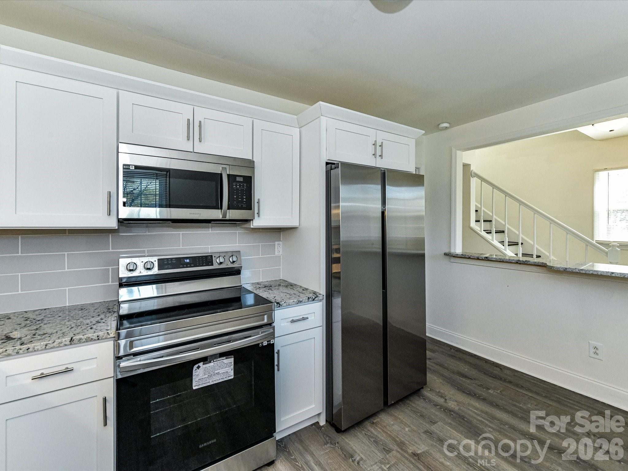 8322 Knights Bridge Road Charlotte, NC 28210 - Photo 18 of 37 a kitchen with stainless steel appliances granite countertop a refrigerator stove and microwave