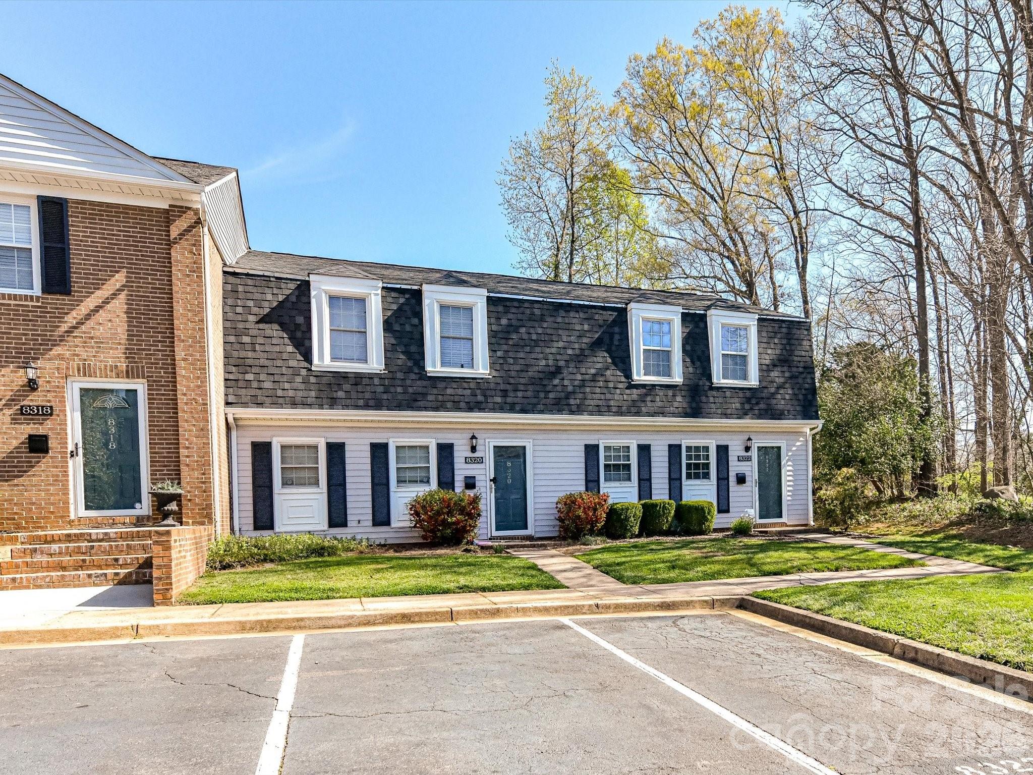 8322 Knights Bridge Road Charlotte, NC 28210 - Photo 4 of 37 a front view of a brick house with a big yard and large trees