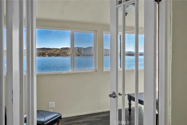 a view of a room that has a large window and wooden floor