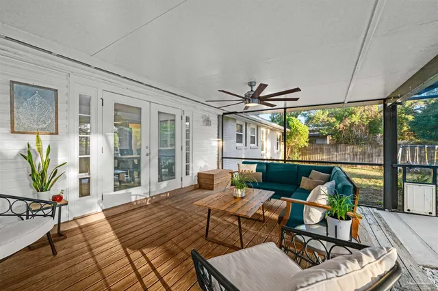 a living room with furniture a rug and a floor to ceiling window