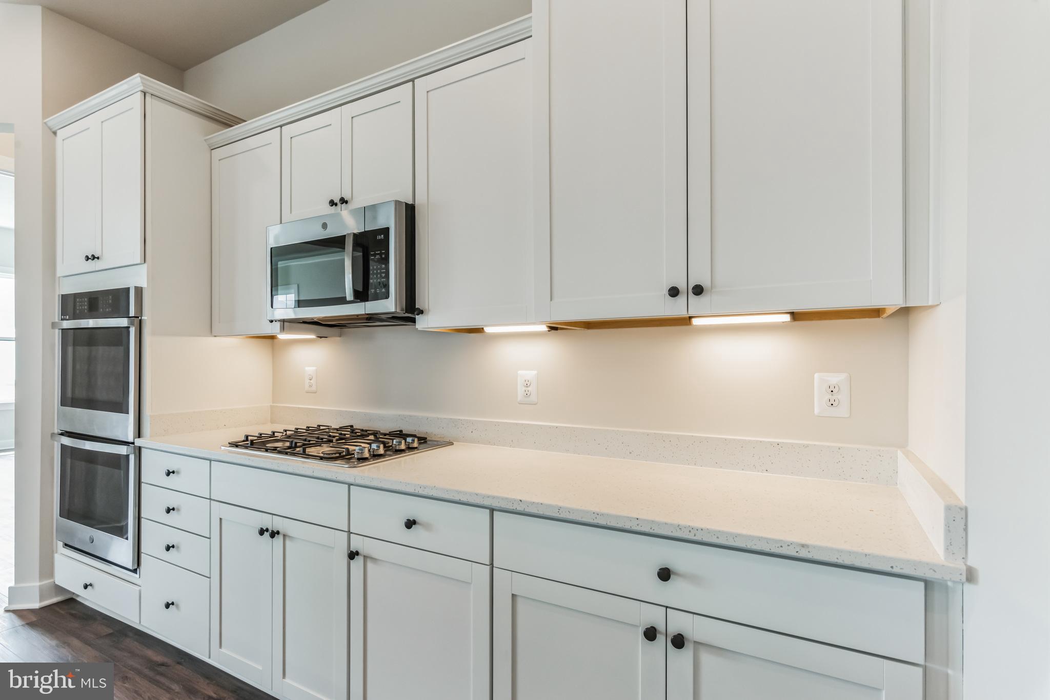 21 Golden Raintree Court Middletown, DE 19709 - Photo 5 of 28 a kitchen with white cabinets and appliances
