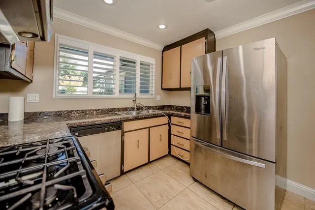 a kitchen with granite countertop a refrigerator and a sink