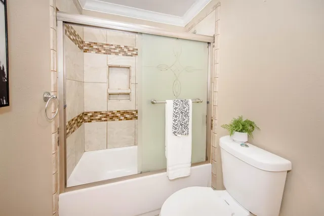 a backyard of a house with plants and a large tree