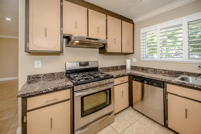 a kitchen with stainless steel appliances granite countertop a stove and a sink