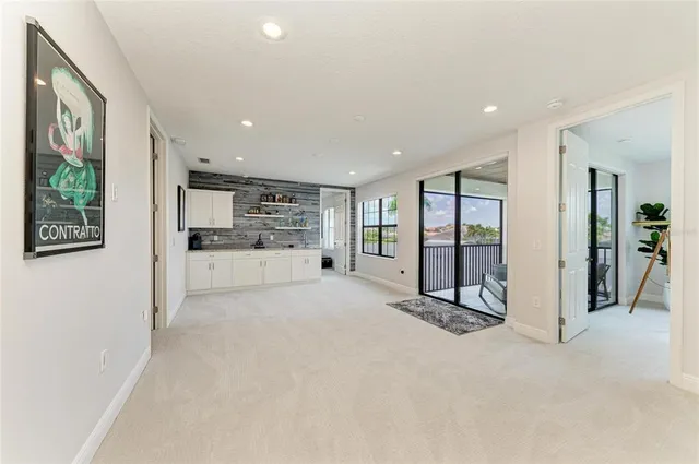 a living room with furniture a flat screen tv and a floor to ceiling window