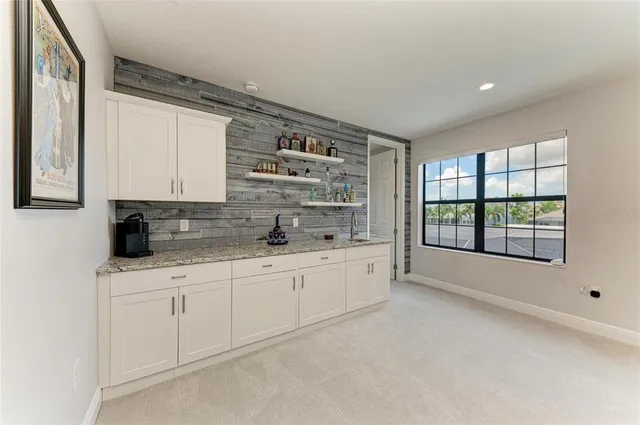 an aerial view of ocean and residential houses with outdoor space
