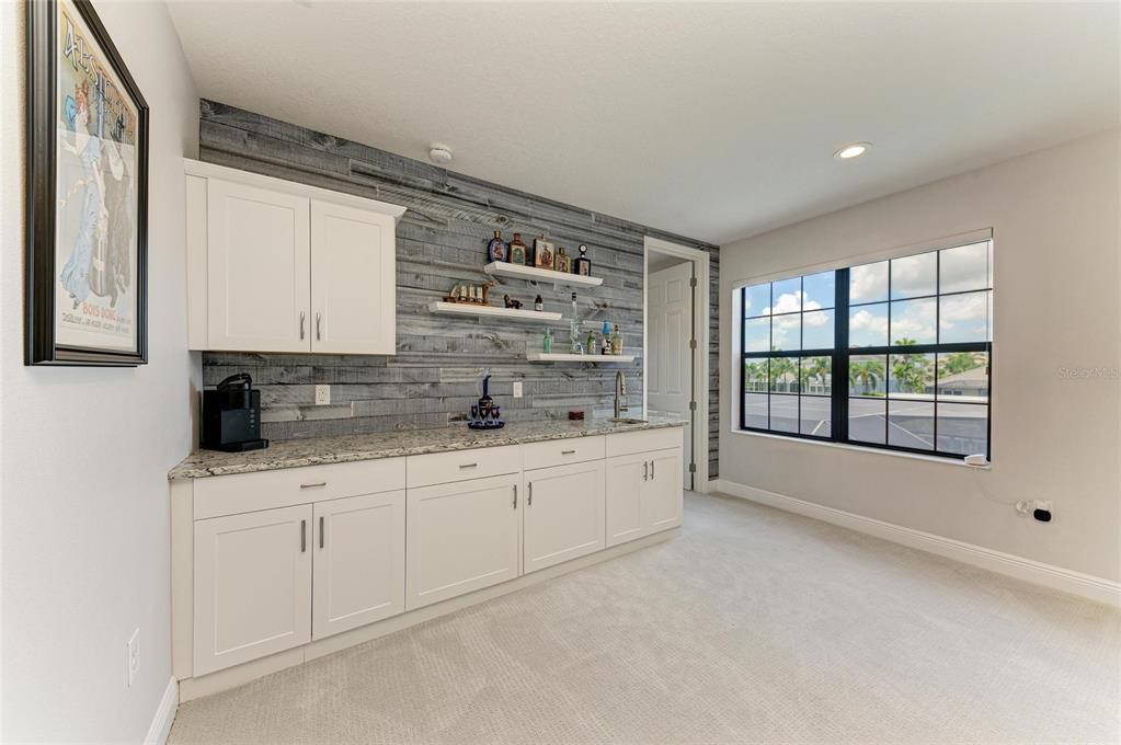 544 Fore Drive Bradenton, FL 34208 - Photo 48 of 95 a large white kitchen with granite countertop a sink and white cabinets next to a window