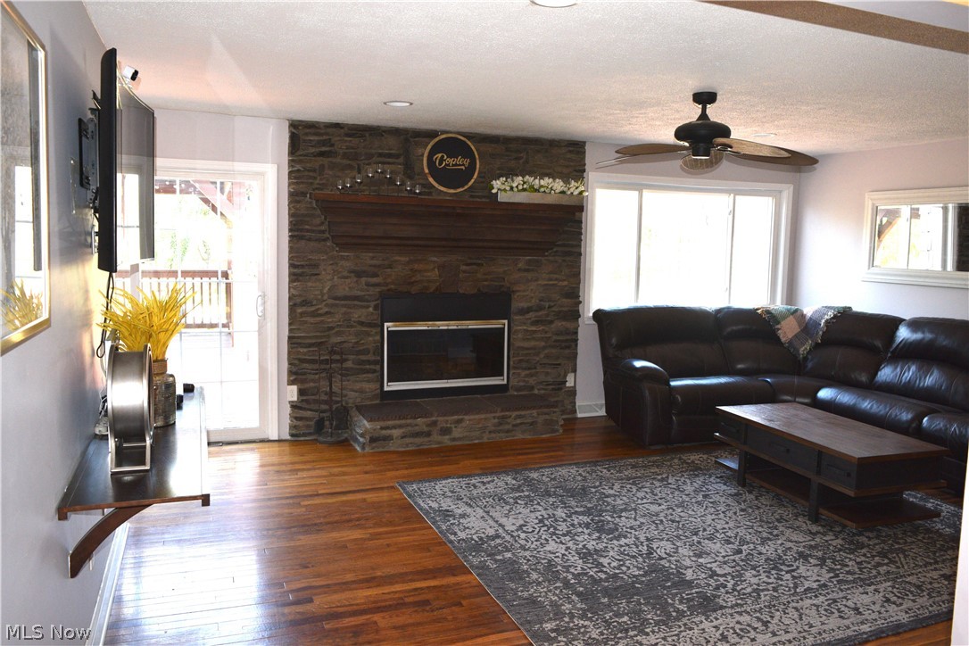 3285 Hemphill Road Barberton, OH 44203 - Photo 14 of 50 Living room with ceiling fan, dark hardwood / wood-style floors, a textured ceiling, and a fireplace