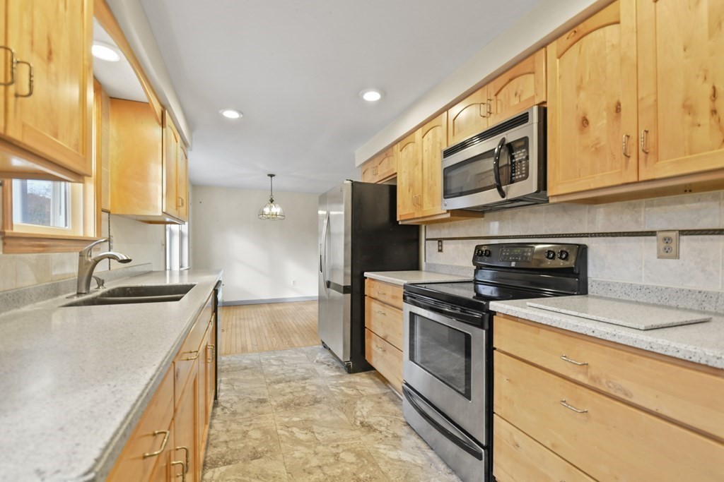 50 Perry Road Rindge, NH 03461 - Photo 16 of 36 a kitchen with stainless steel appliances granite countertop a sink a stove and cabinets