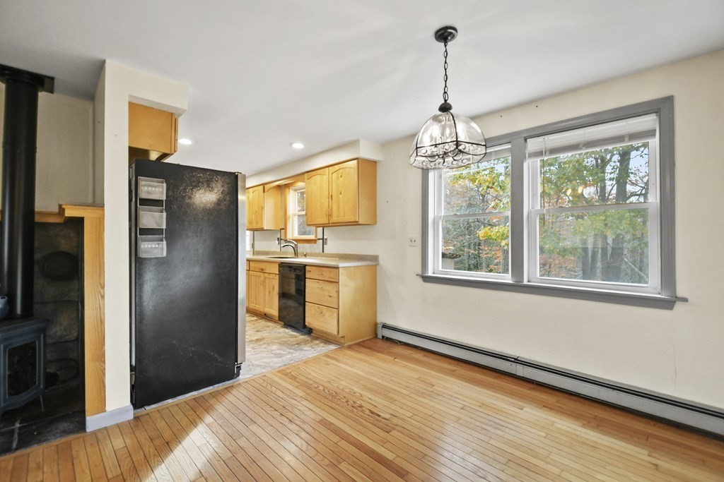 50 Perry Road Rindge, NH 03461 - Photo 8 of 36 a kitchen with stainless steel appliances granite countertop a refrigerator a sink dishwasher a stove and a dining table with wooden floor