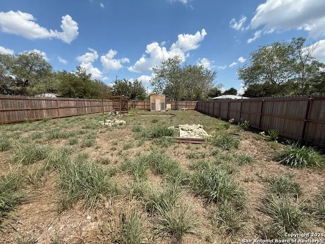 a view of backyard with wooden fence