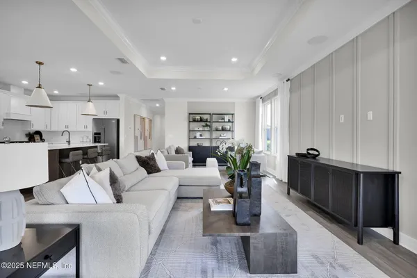 a living room with furniture kitchen view and a potted plant