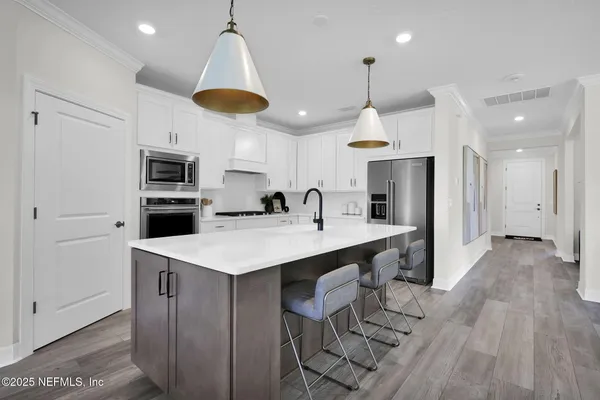a kitchen with white cabinets appliances and sink