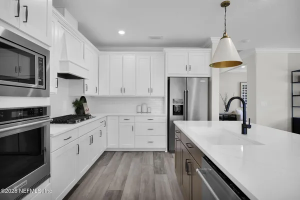 a kitchen with counter top space sink and living room view
