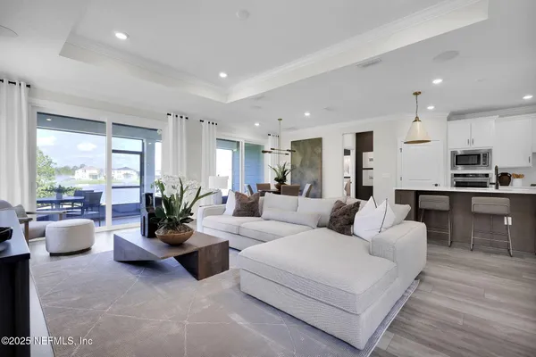 a living room with furniture wooden floor and a view of kitchen