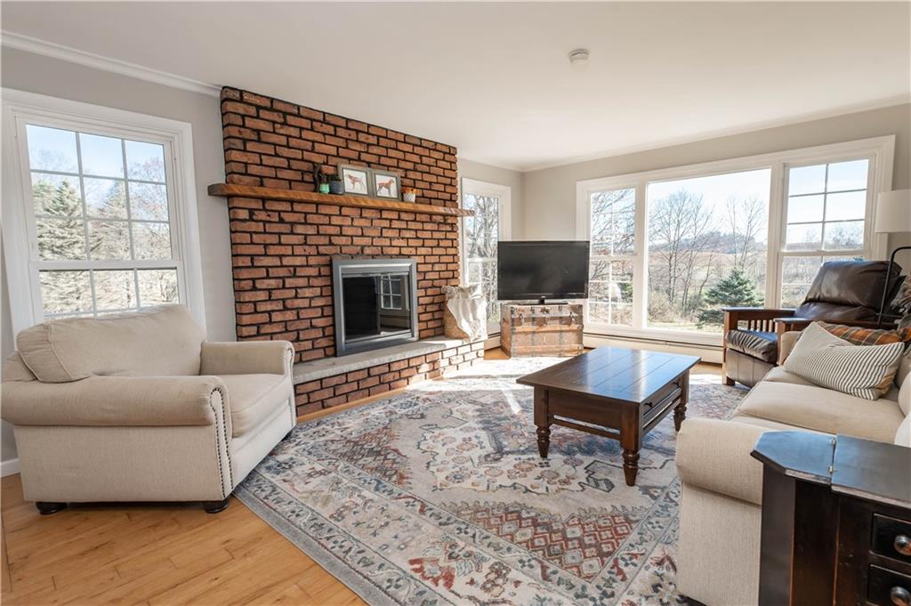 2555 Morrow Road Home, PA 15747 - Photo 2 of 24 a living room with furniture a fireplace a flat screen tv and a large window