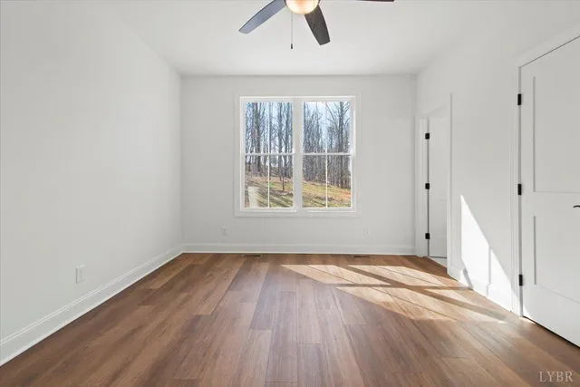 a view of a room with wooden floor and a ceiling fan