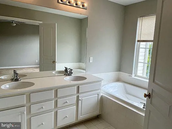 a bathroom with a tub sink and mirror