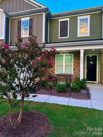 a view of a house with a yard and potted plants