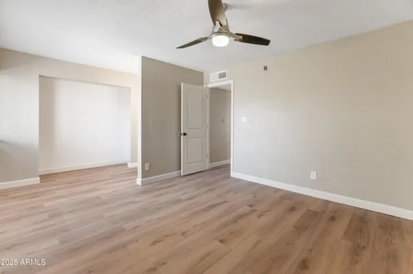 a view of an empty room with wooden floor
