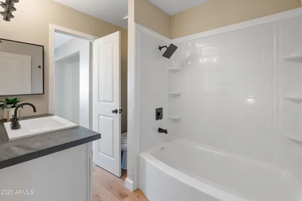 a bathroom with a granite countertop sink a mirror a shower and a bathtub