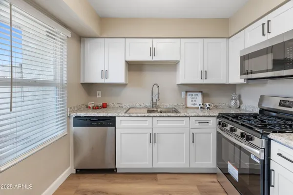 a kitchen with stainless steel appliances granite countertop a sink stove and microwave