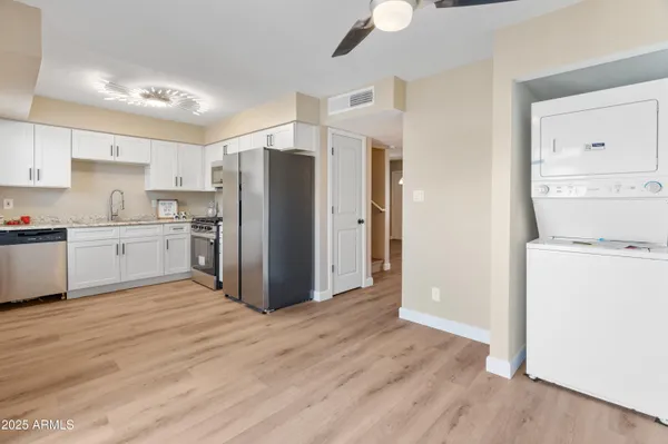 a kitchen with a refrigerator a stove and white cabinets