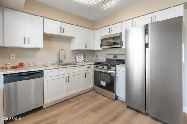 a kitchen with stainless steel appliances a sink cabinets and a refrigerator