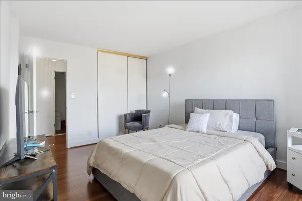 a bedroom with a large bed and a chandelier
