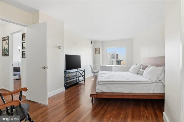 a bedroom with a bed and wooden floor