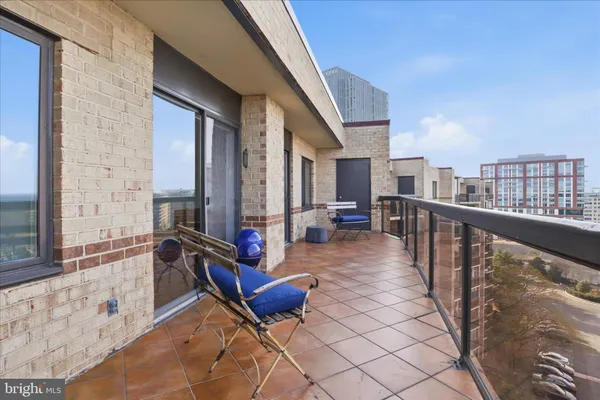 a view of a balcony with chairs and wooden fence
