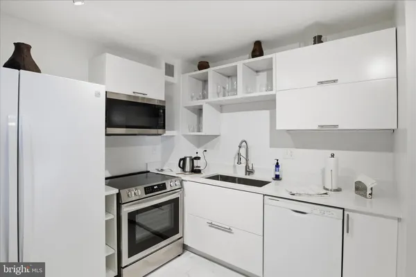 a kitchen with cabinets appliances a sink and a counter top