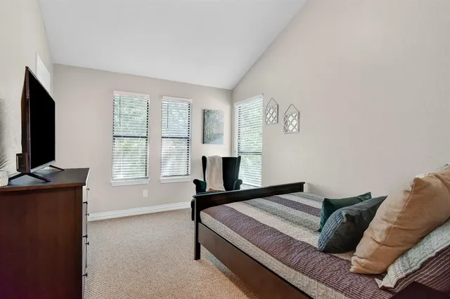 a living room with furniture a flat screen tv and a window