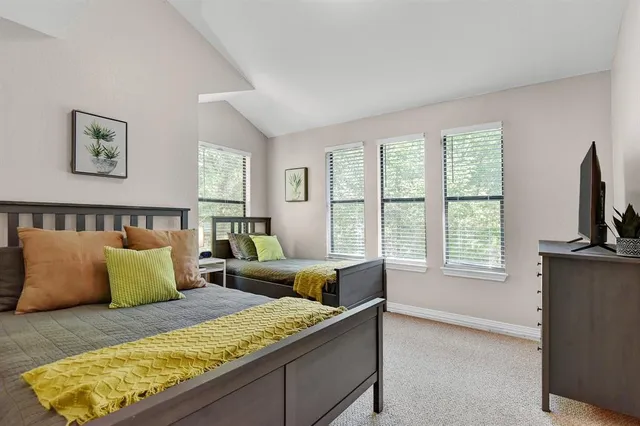 a bedroom with a bed a couch and a window