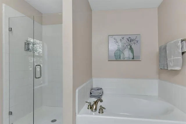 a white bath tub sitting next to a white sink and vanity