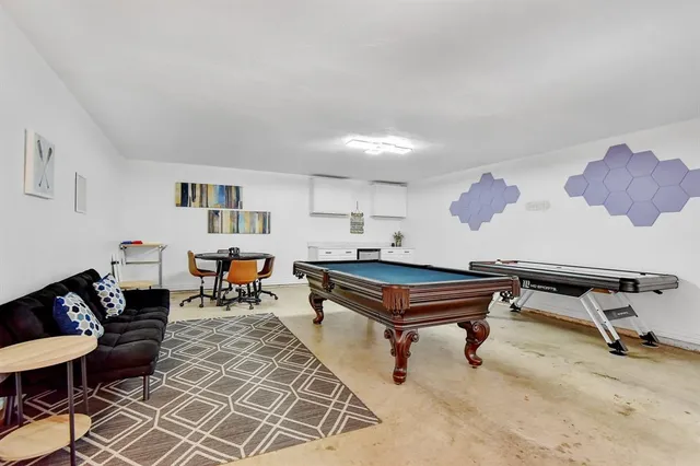 a living room with furniture a pool table and a window