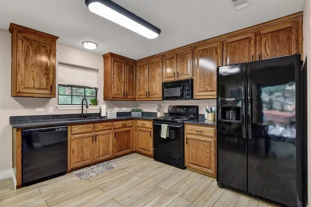 a kitchen with wooden cabinets stainless steel appliances and a window