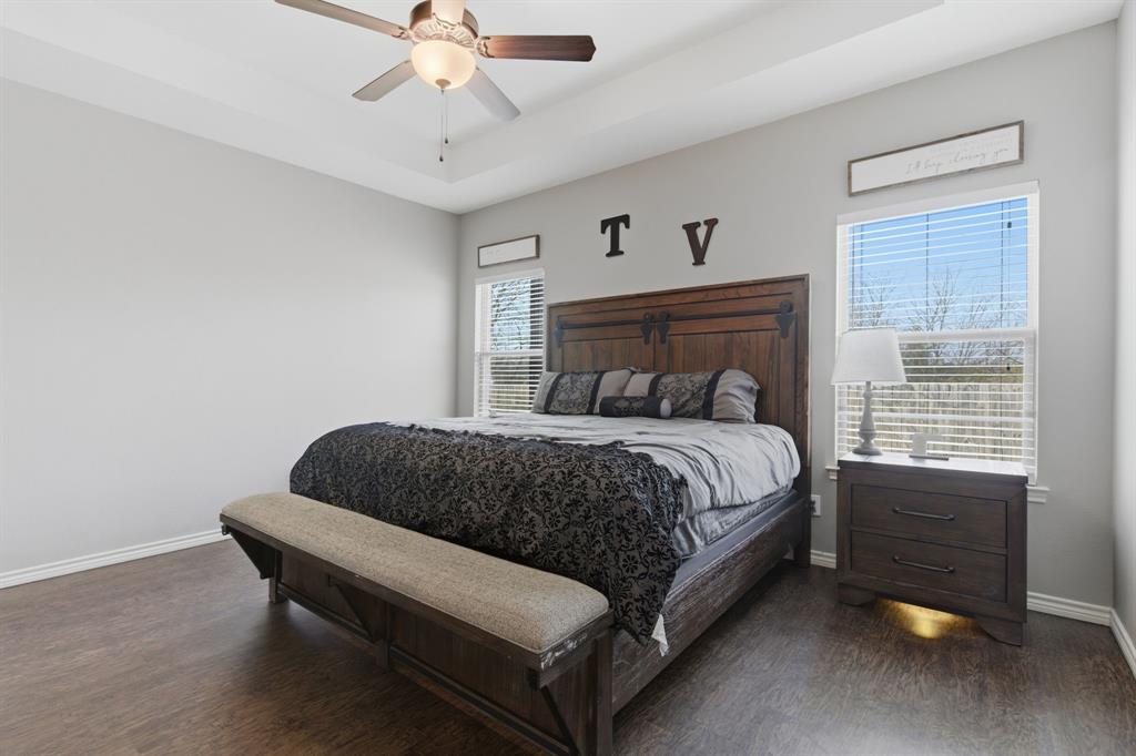 711 Hadley Lane Valley View, TX 76272 - Photo 18 of 40 Bedroom featuring dark wood-type flooring, a ceiling fan, and a tray ceiling