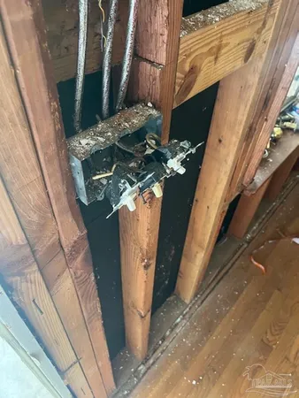 a vase with flowers sitting on a floor in front of a door