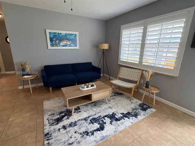 a living room with furniture a rug and a window