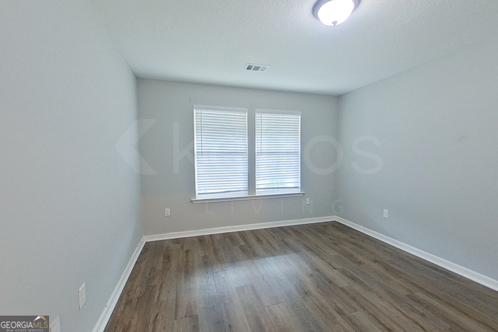 132 Cottage Grove Road Brunswick, GA 31525 - Photo 6 of 17 an empty room with wooden floor and windows