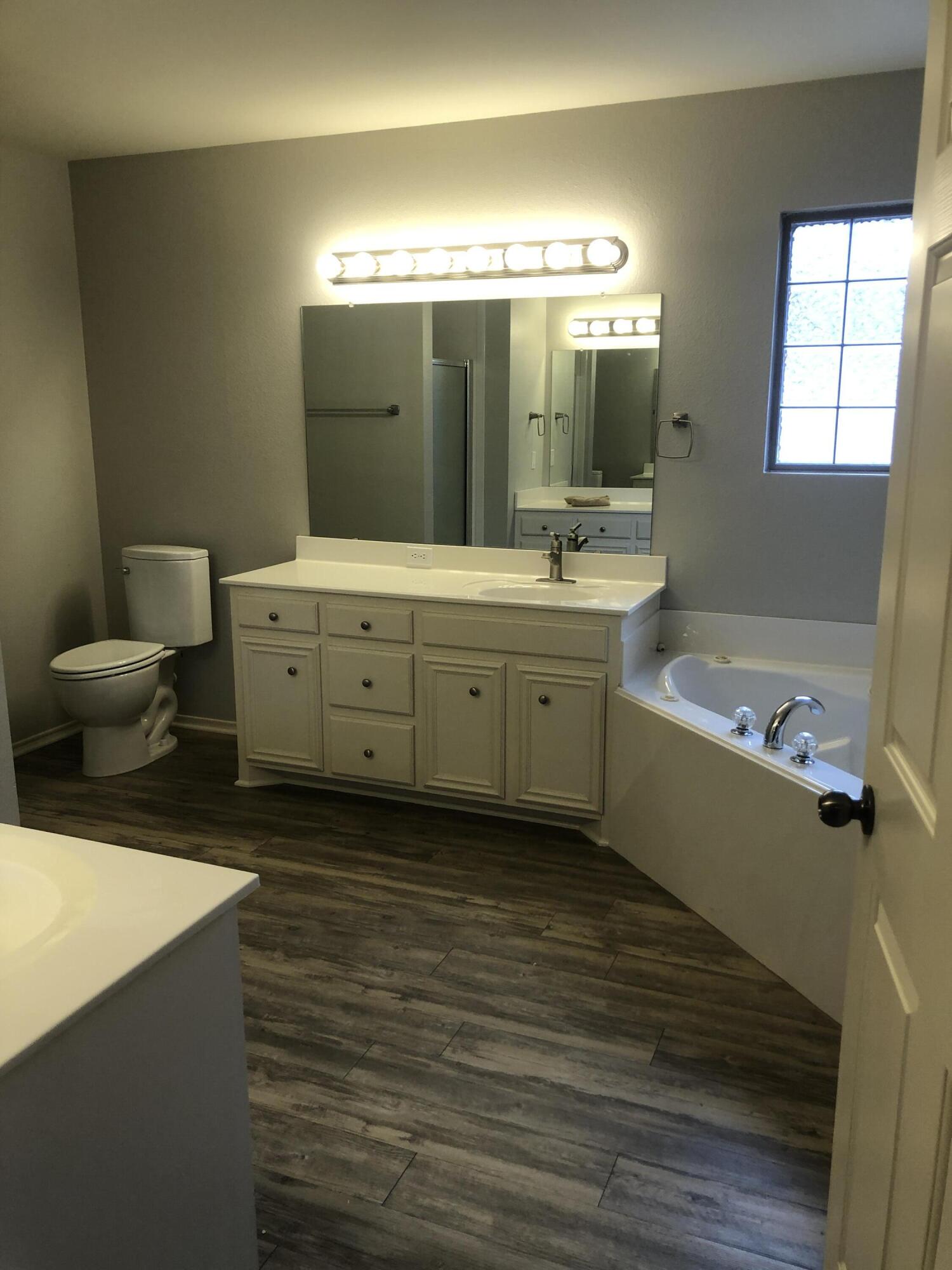 7528 84th Street Lubbock, TX 79424 - Photo 16 of 20 a spacious bathroom with a double vanity sink toilet mirror and bathtub