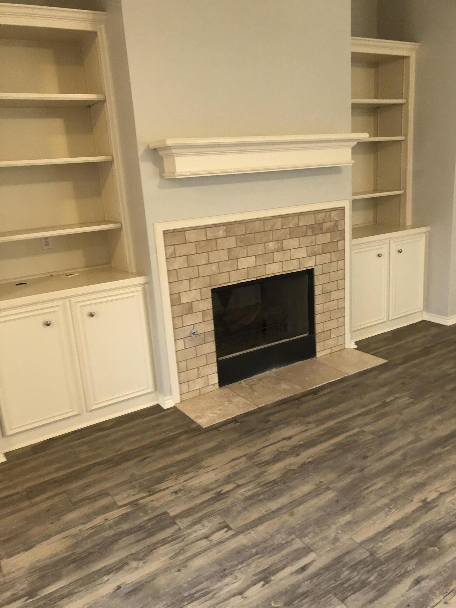 7528 84th Street Lubbock, TX 79424 - Photo 5 of 20 a view of an empty room with wooden floor and a fireplace