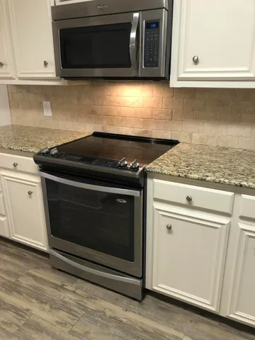 a stove top oven sitting inside of a kitchen