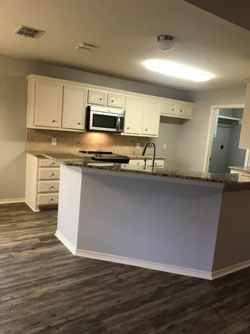 a kitchen with stainless steel appliances granite countertop a sink a stove a microwave a sink and cabinets