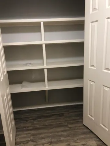 a view of walk in closet with empty racks