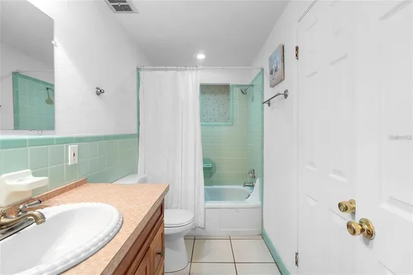 a bathroom with a granite countertop sink a toilet and shower