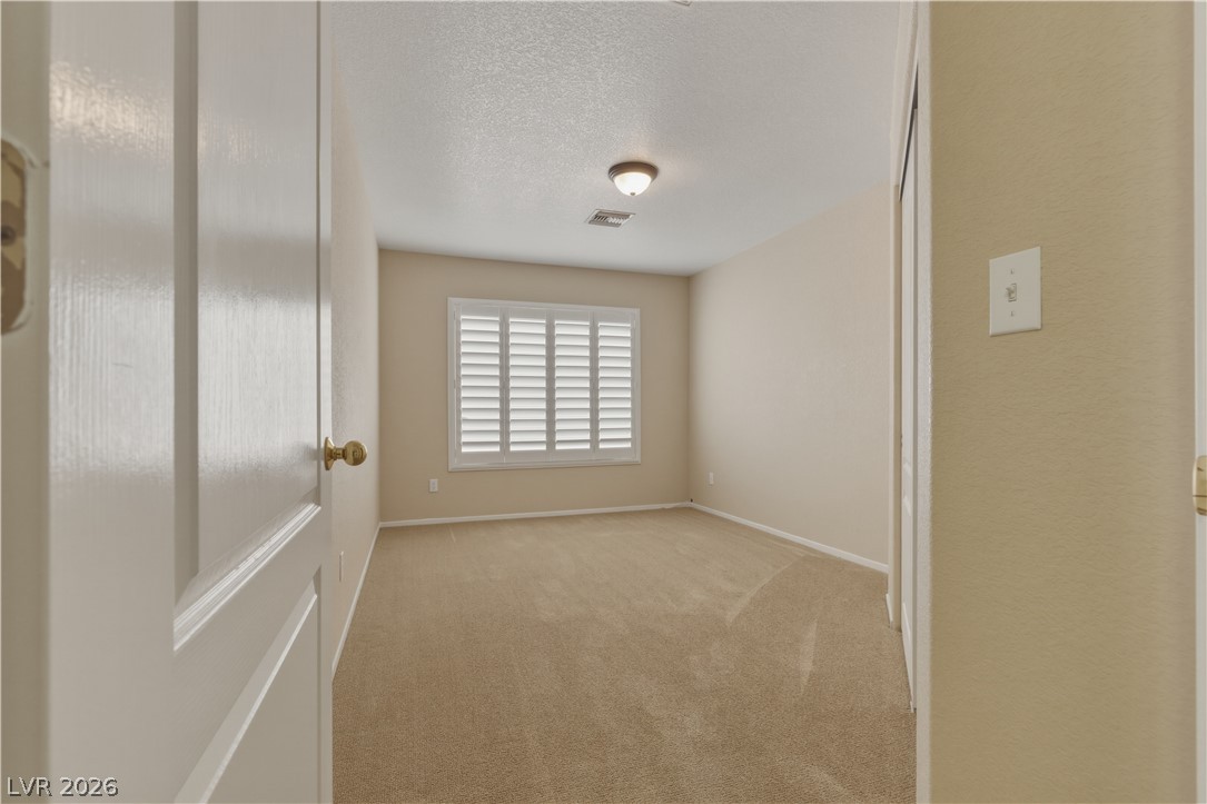 29 Olive Tree Henderson, NV 89074 - Photo 47 of 60 This cozy bedroom features carpeted flooring and window shutters, creating a comfortable and private space.